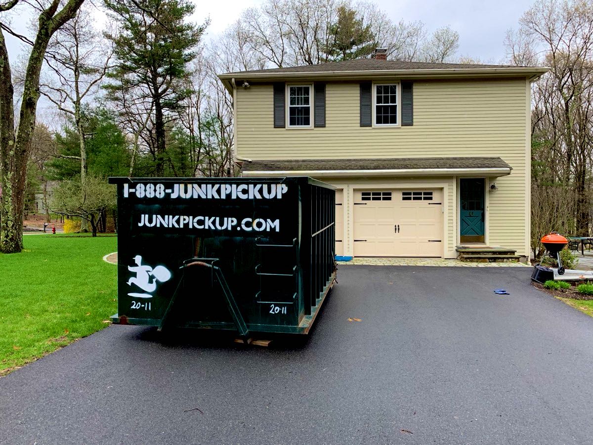 20 yard dumpster on wood planks in a home driveway