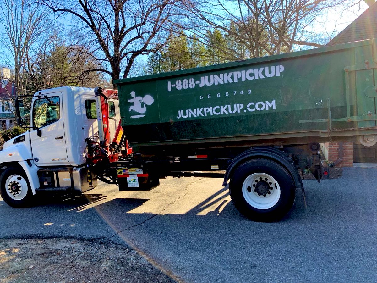 Roll-off truck delivering a dumpster in a Massachusetts neighborhood