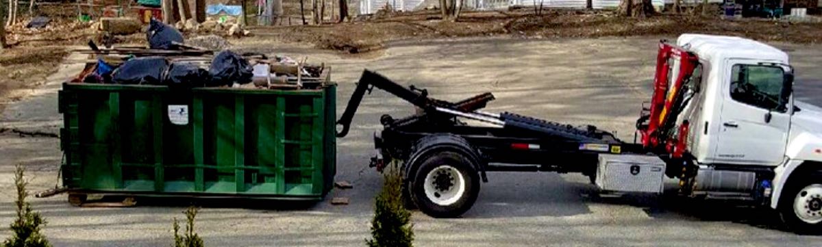 Roll-off truck setting a dumpster down